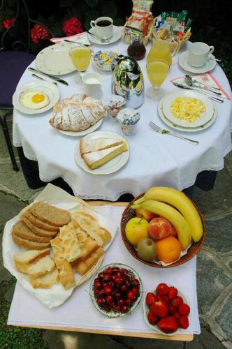a white table topped with plates of food and fruit at Il Giardino Incantato in Monterosso al Mare
