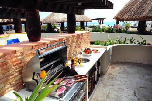 an outdoor kitchen with a counter and a sink at El Taj Oceanfront and Beachside Condo Hotel in Playa del Carmen