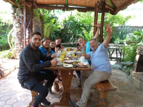 a group of people sitting around a wooden table at Hotel y Spa Isla de Baños in Baños