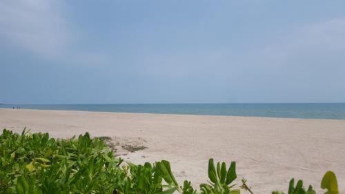 an empty beach with the ocean in the background at The Rain Cha Am by Paka in Cha Am