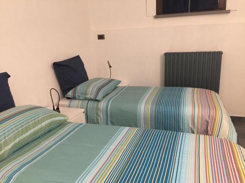 two beds in a room with two at All' Ombra del Portico in Bologna