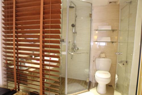 a bathroom with a toilet and a glass shower at Elite Central Hotel Hanoi in Hanoi