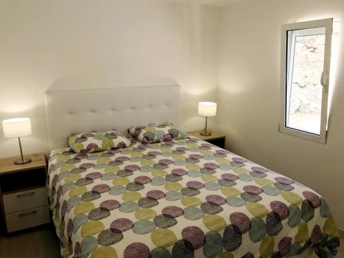 Un dormitorio con una cama y dos lámparas y una ventana. en San Agustin sea view, en San Agustín