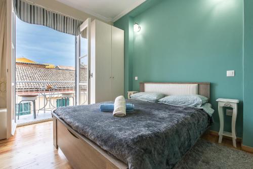 um quarto com uma cama grande e uma janela grande em Pierre Marie Corfu Old Town Home em Corfu Town