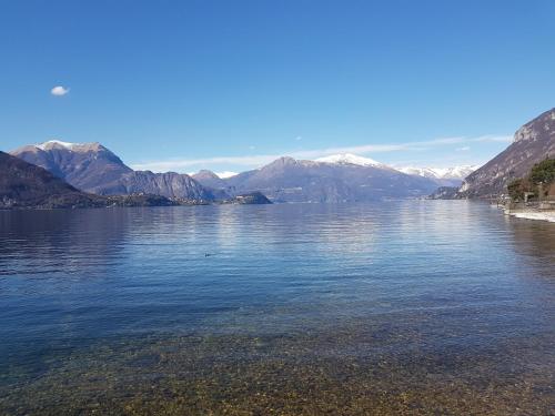 a large body of water with mountains in the background at Foresteria Lombarda La Spiaggia in Lierna