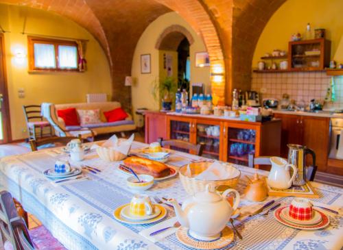 cocina con mesa y set de té en A Casa di Lizzy B&B, en Montelopio