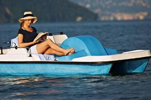 a woman sitting on a boat in the water at House of Harmony in Stäfa