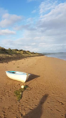 a boat sitting on the sand on a beach at The Farthings in Braunton
