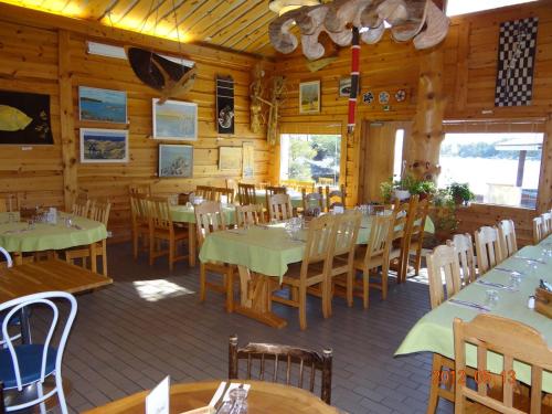 une salle à manger avec des tables et des chaises dans un restaurant dans l'établissement Vuosnaisten Meriasema, à Kustavi