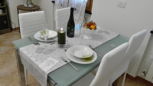 a dining table with white plates and a bottle of wine at Maison Verika in Chiavari