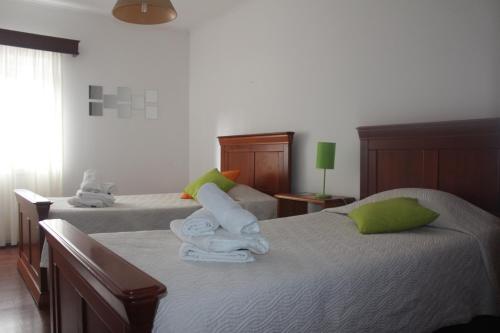 um quarto com 2 camas e toalhas em ApartAnita em Ponta Delgada