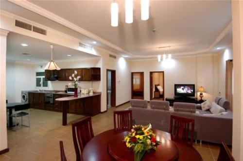 een woonkamer en een keuken met een tafel en een bank bij Ramee Suite Apartment 4 in Manamah