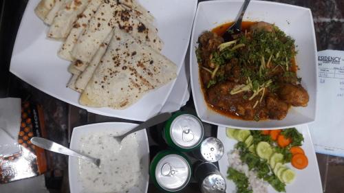 a table with two plates of food and some bread at Patel Residency Guest House 2 in Karachi