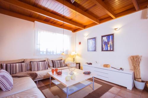 een woonkamer met een bank en een tafel bij Villa Hibiscus Centrum Corralejo Beach Private Pool Family in Corralejo