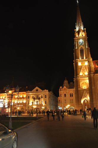 a large building with a clock tower at night at Apartment Eugen in Novi Sad