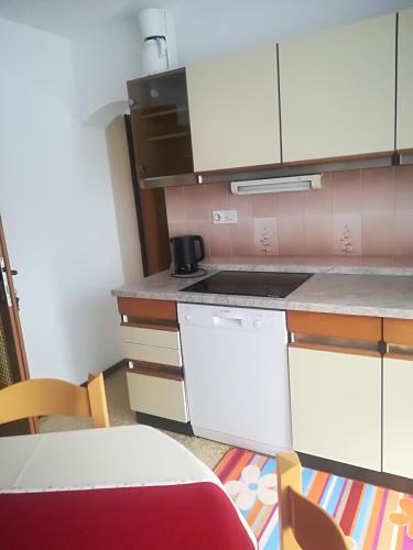 a kitchen with white cabinets and a stove top oven at Apartments & Rooms Stare in Bohinj