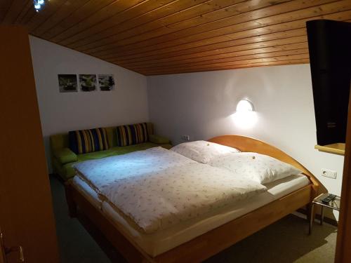 1 cama en un dormitorio con techo de madera en Haus Kathrin, en Kaprun