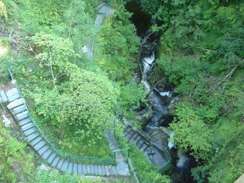 an overhead view of a waterfall and stairs next to a river at Highland Moors in Llandrindod Wells