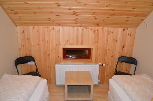 a room with two beds and a tv on the wall at Laugarfell Accommodation & Hot Springs in Laugarfell
