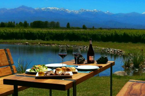 a picnic table with wine glasses and a plate of food at Casa Petrini in Tupungato