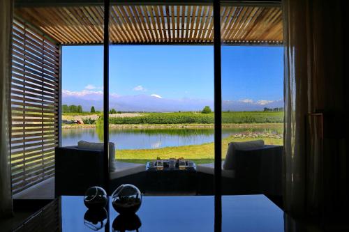 a room with a large window with a view of a river at Casa Petrini in Tupungato