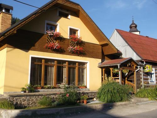 a house with flower boxes on the windows at Chata Holica PIENINY in Lesnica