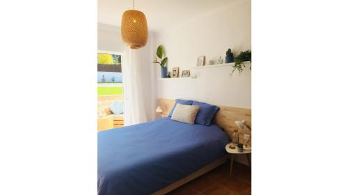 a bedroom with a blue bed and a window at B&B Villa Pinos Málaga in Alhaurín de la Torre