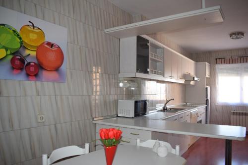 una cocina con una mesa con un jarrón de flores en Apartamento Cantalejo, en Cantalejo