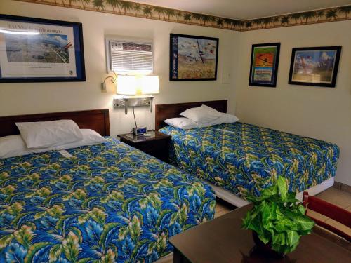 Habitación de hotel con 2 camas y mesa en Amelia's Landing en Port Aransas