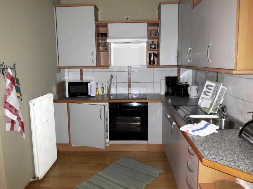 eine Küche mit weißen Schränken und einer Arbeitsplatte in der Unterkunft Haus Margrit Ferienwohnung in Sonnenlage in Golling an der Salzach