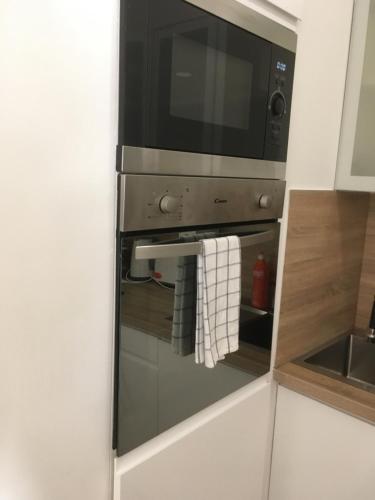 un horno de microondas con una toalla colgando de él en Residence de luxe tout confort en Ginebra
