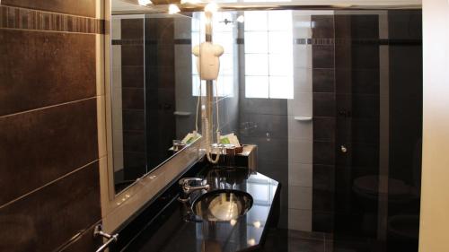 y baño con lavabo y espejo. en Hotel Centro en San José de Mayo