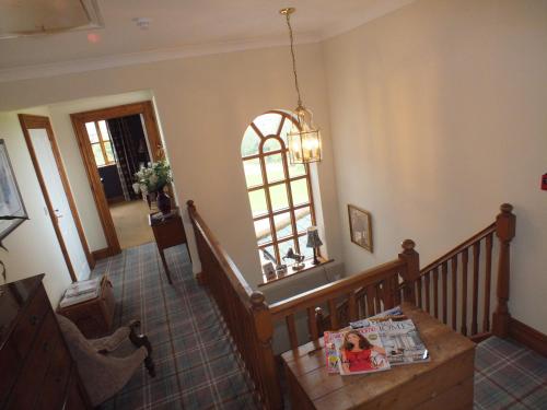 a room with a staircase with a table and a window at Springwood in Seahouses