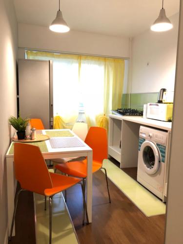 a kitchen with a table and chairs and a washing machine at New Central Roof top view in Bucharest
