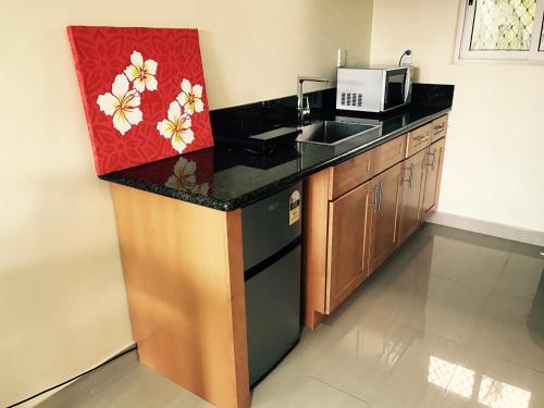 a kitchen with a sink and a microwave at Samoana Boutique Hotel in Apia