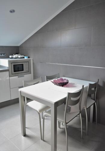a white table and chairs in a kitchen at Apartamento Vila O Valadouro in O Valadouro