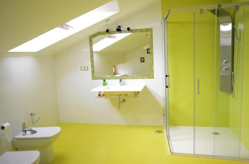 a bathroom with a toilet and a sink and a mirror at Apartamento Vila O Valadouro in Ferreira