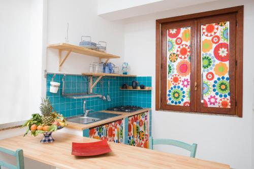 a kitchen with a table with a sink and a window at Il Vicolo B&B in Milazzo