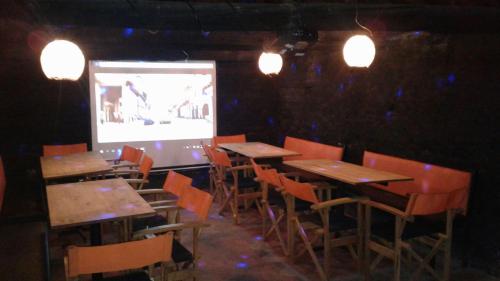 a room with tables and chairs and a projection screen at Casa Vieja Posada in Pesca