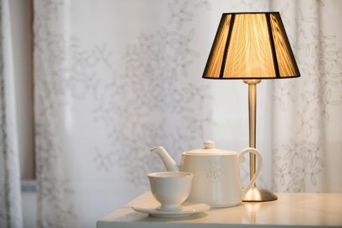 a table with a tea pot and a lamp on it at Il Vicolo B&B in Milazzo