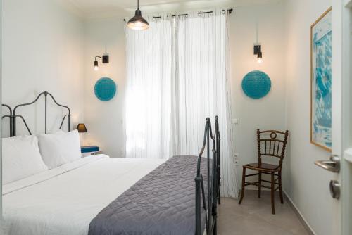 a bedroom with a bed and a chair next to a window at 1930's Athenian House in Athens