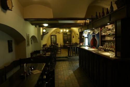 un restaurant avec un bar doté de tables et de chaises dans l'établissement Hotel U Zlateho Andela, à Pardubice