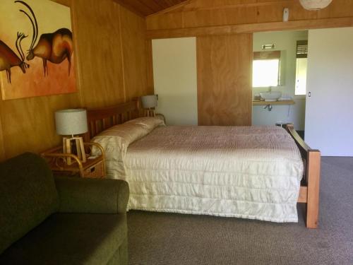 a bedroom with a bed and a couch in a room at The Rocks Chalets in Takaka