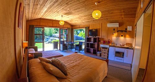 a bedroom with a bed and a kitchen in a room at The Rocks Chalets in Takaka