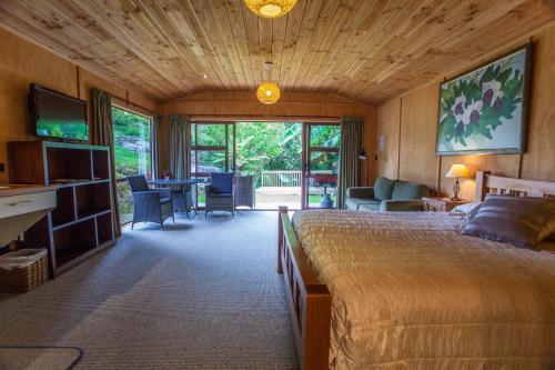 a bedroom with a large bed and a living room at The Rocks Chalets in Takaka