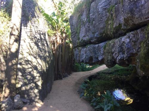 a stone wall with a path between two rocks at The Rocks Chalets in Takaka