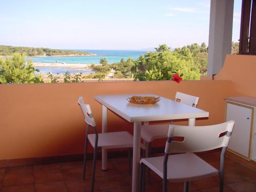 a table and chairs with a view of the ocean at Residenze Coda Cavallo in San Teodoro