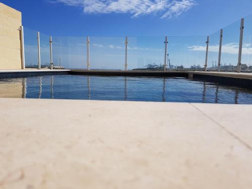 a pool of water with a bridge in the background at Fisherman's Cove Guesthouse in Marsaxlokk