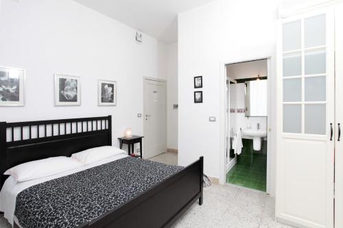 a bedroom with a black and white bed and a bathroom at Il Vicolo B&B in Milazzo
