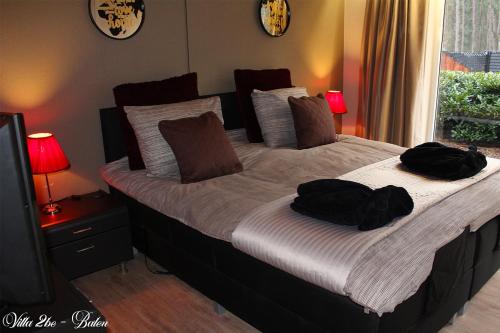 a bedroom with a large bed with two bags on it at villa 2be in Balen
